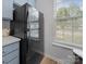 Kitchen detail featuring a black refrigerator next to soft blue cabinetry and a sunlit window at 4607 Silk Tree Ln, Rock Hill, SC 29732