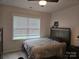Neutral bedroom featuring a double bed, soft carpet, and natural light from a large window at 5000 Britannia Blvd, Waxhaw, NC 28173