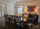 A dining room with a long wood table with seating for eight, a decorative sideboard, and an attractive chandelier at 5000 Britannia Blvd, Waxhaw, NC 28173