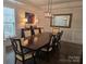 Bright dining room with a dark wood table, stylish chairs, decorative buffet, and modern lighting fixture at 5000 Britannia Blvd, Waxhaw, NC 28173