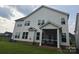 View of the back of the home featuring a screened-in porch and large windows at 5000 Britannia Blvd, Waxhaw, NC 28173