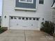 Attached two-car garage with carriage-style doors and decorative hardware at 5000 Britannia Blvd, Waxhaw, NC 28173