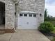 Two-car garage door with decorative hardware and stone accents at 5000 Britannia Blvd, Waxhaw, NC 28173