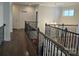 Upstairs hallway with wood floors, decorative railing, and pendant lighting, providing a bright, open feel at 5000 Britannia Blvd, Waxhaw, NC 28173