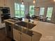Open kitchen design featuring a large sink, island seating, and views to the dining area at 5000 Britannia Blvd, Waxhaw, NC 28173