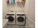 Laundry room includes front load washer and dryer, tile floor, and shelving at 5000 Britannia Blvd, Waxhaw, NC 28173