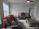 A living room area with comfortable seating, a neutral color scheme, and natural light from the windows at 5000 Britannia Blvd, Waxhaw, NC 28173
