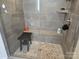 Modern shower with bench seating, a hand sprayer, and decorative stone flooring at 5000 Britannia Blvd, Waxhaw, NC 28173