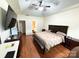 Spacious bedroom featuring a ceiling fan, wood floors, and an en-suite bathroom at 5111 Elementary View Dr, Charlotte, NC 28269