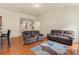 Comfortable living room with hardwood floors and dual reclining sofas under bright, natural light at 5111 Elementary View Dr, Charlotte, NC 28269