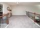 Hallway with gray walls and carpet, and wood railing leading to the lower level at 512 Rosebush Ln, Clover, SC 29710