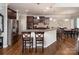 Open kitchen features wood floors, granite counters, stainless appliances, breakfast bar, and dining area at 512 Rosebush Ln, Clover, SC 29710
