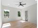 Sun-drenched bedroom featuring two windows, wood floors, and ceiling fan at 5526 Brookwood Ln, Hickory, NC 28602
