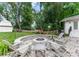 Backyard featuring a stone firepit area, a playset, an outbuilding and lush greenery at 5533 Murrayhill Rd, Charlotte, NC 28210