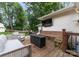 Beautiful deck with outdoor seating, a fire pit, a mounted tv, and lush greenery views at 5533 Murrayhill Rd, Charlotte, NC 28210