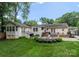 Beautiful home with a backyard featuring an outdoor kitchen, deck, firepit, and lush greenery at 5533 Murrayhill Rd, Charlotte, NC 28210