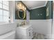 Charming bathroom features modern fixtures, vanity with storage, round mirror, and white wainscoting at 5533 Murrayhill Rd, Charlotte, NC 28210