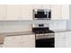 Close-up of a kitchen featuring stainless steel appliances, white cabinets, and tile backsplash at 5775 Soft Shell Dr # 310, Lancaster, SC 29720