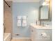 Well-lit bathroom with a vanity, toilet, and tiled shower-tub combo at 5909 Ryder Ave, Charlotte, NC 28226