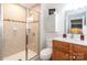 Well-lit bathroom features a glass-enclosed shower, a stylish vanity with storage, and neutral-toned tile work at 5909 Ryder Ave, Charlotte, NC 28226