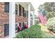A cozy front porch featuring classic brickwork, supportive pillars, and charming outdoor seating at 5909 Ryder Ave, Charlotte, NC 28226