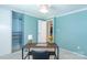 A blue office space with a wooden desk, a large closet, and light-colored carpet at 5909 Ryder Ave, Charlotte, NC 28226