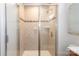 Tiled shower enclosure features glass doors and a mosaic accent stripe at 5909 Ryder Ave, Charlotte, NC 28226