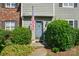 Close-up of a charming entryway with an American flag, shrubs, and brick accents at 6044 Heath Valley Rd, Charlotte, NC 28210