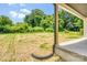 A large, grassy backyard with mature trees is seen from the home's covered back porch at 707 W Davidson Ave, Gastonia, NC 28052