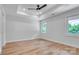 Bedroom with tray ceiling, ceiling fan, and two windows offering natural light at 707 W Davidson Ave, Gastonia, NC 28052