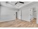Main bedroom with a tray ceiling, ceiling fan, and light hardwood floors at 707 W Davidson Ave, Gastonia, NC 28052