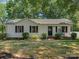 Charming one-story home featuring a well-maintained lawn, black shutters, and inviting front porch bench at 713 Springfield Nw Dr, Concord, NC 28027