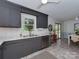 Kitchen with stainless steel appliances, gray cabinets, subway tile, and a view into the dining area and backyard at 713 Springfield Nw Dr, Concord, NC 28027