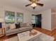 Cozy living room with hardwood floors, modern sofa, and ample natural light from the large front window at 713 Springfield Nw Dr, Concord, NC 28027