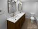 Bathroom features double vanity with gold fixtures and updated shower at 7134 Rollingridge Dr, Charlotte, NC 28211