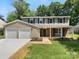 Charming two-story home featuring a two-car garage, neutral siding, and lush landscaping at 7134 Rollingridge Dr, Charlotte, NC 28211