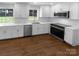 Modern kitchen with white cabinets, stainless steel appliances, hardwood flooring, and granite countertops at 7134 Rollingridge Dr, Charlotte, NC 28211