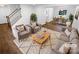 Bright staged living room with hardwood floors, neutral furniture, and a view into the dining room at 7134 Rollingridge Dr, Charlotte, NC 28211