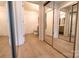 Bright bathroom with wood-look floors, mirrored closet, and white cabinets at 720 Governor Morrison St # 221, Charlotte, NC 28211