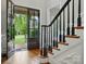 Entryway featuring a staircase with hardwood steps, contrasting dark railings, and a glass-paneled front door at 748 Land Fall Dr, Rock Hill, SC 29732