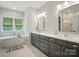 Bright bathroom features a soaking tub under a window and a double vanity with marble countertops at 7818 Russell Rd, Indian Trail, NC 28079