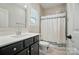 Bathroom featuring a single vanity with dark cabinets and a shower with a gray and white curtain at 7818 Russell Rd, Indian Trail, NC 28079