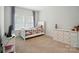 Neutral bedroom with a bed, dresser, and natural light from a bright window at 7818 Russell Rd, Indian Trail, NC 28079