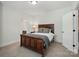 Cozy bedroom with a dark wood bed frame, bedside table, and adjacent bathroom at 7818 Russell Rd, Indian Trail, NC 28079
