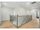 Spacious hallway with light hardwood floors, a black iron railing, and natural light at 7818 Russell Rd, Indian Trail, NC 28079