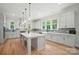 Bright kitchen with white cabinets, subway tile backsplash, and a large island at 7818 Russell Rd, Indian Trail, NC 28079