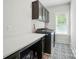 Well-lit laundry room with storage, white countertops, and a dark patterned floor at 7818 Russell Rd, Indian Trail, NC 28079