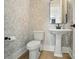 Elegant powder room with pedestal sink and patterned wallpaper at 7818 Russell Rd, Indian Trail, NC 28079