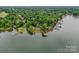 Aerial view of lakeside house surrounded by mature trees, multiple docks and deep waterfront at 7945 Placid Ct, Denver, NC 28037
