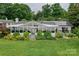 Charming lake house with well-manicured lawn, lush landscaping and solar panels on roof at 7945 Placid Ct, Denver, NC 28037